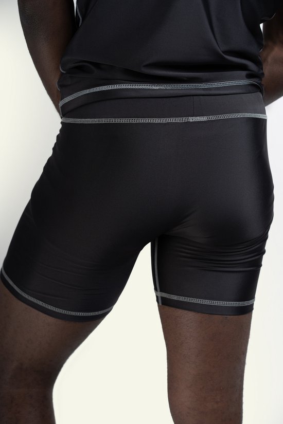 Short de sport noir moulant avec coutures grises, porté par un homme.