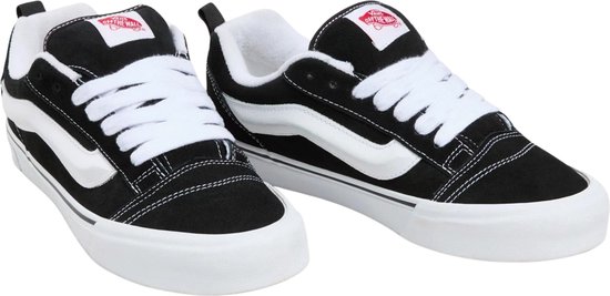 Une paire de baskets noires Vans Knu Skool avec bande latérale blanche, lacets et semelles blanches.