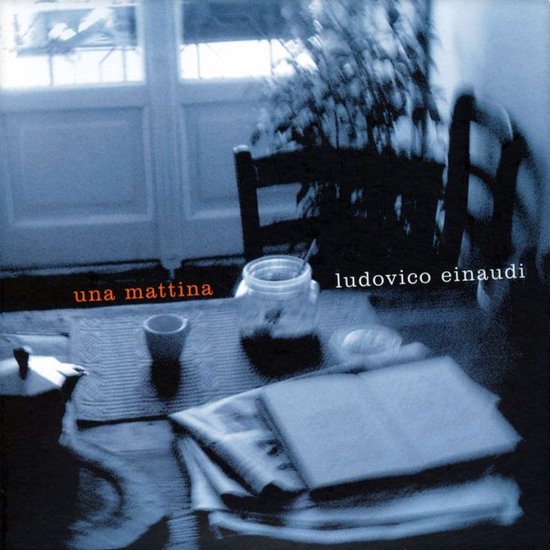 Couverture de CD : "una mattina" en lettres rouges, "ludovico einaudi" en lettres blanches. Une table avec journaux, tasse, pot et cafetière.