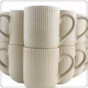 Empilage de tasses blanc cassé avec un subtil motif côtelé, chacune avec une anse.