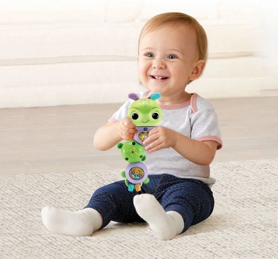 Baby met een groen rupsje in de handen.