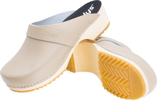 Twee beige Skolys klompen, de ene met zool omhoog. Houten zool, gesp en gestikte randen.