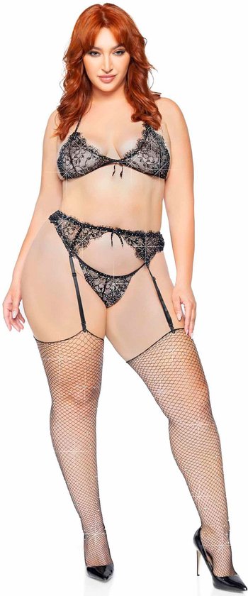Model met rode haren draagt een zwarte kanten beha met strass, een bijpassende string en jarretel, met visnetkousen.
