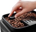 Hand draait aan knop 'Grinder Adjust' in reservoir gevuld met koffiebonen.