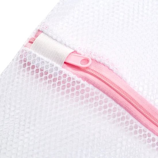 Détail d'un sachet de lavage blanc en maille avec fermeture éclair rose et sangle.