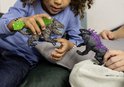 Een kind speelt met de Rock Crusher en Shadow Lynx speelgoedfiguren.