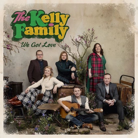The Kelly Family poseert voor de hoes van "We Got Love", met de tekst in kleurrijke letters. Drie mannen en drie vrouwen in landelijke kleding.