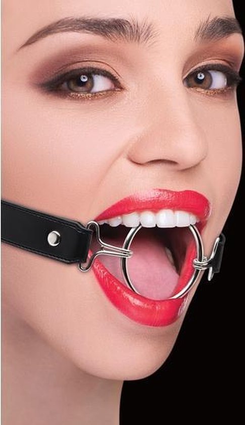 Close-up van een vrouw met rode lippen en een metalen ring gag met zwarte riemen.