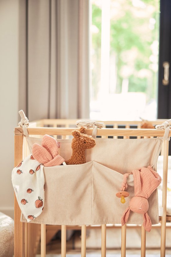 Lichtbeige corduroy boxopberger met perzikkleurige knuffels en een bijtring.