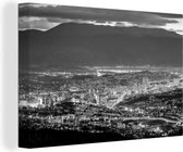 Canvas Schilderij Schemerig Sarajevo voor een berg in Bosnië en Herzegovina - zwart wit - 60x40 cm - Wanddecoratie