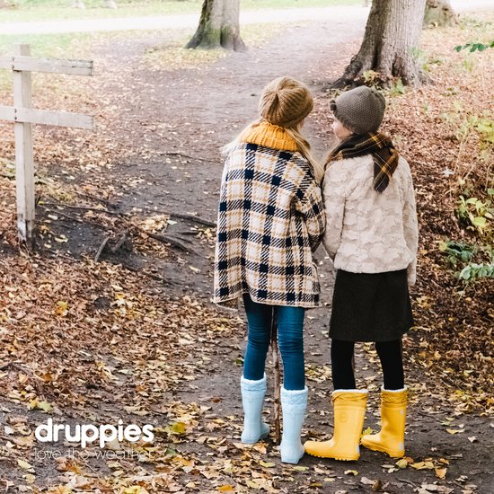 Twee meisjes met hun rug naar de camera, kijkend naar een herfstpad. Ze dragen mutsen, sjaals, jassen en laarzen in verschillende kleuren.