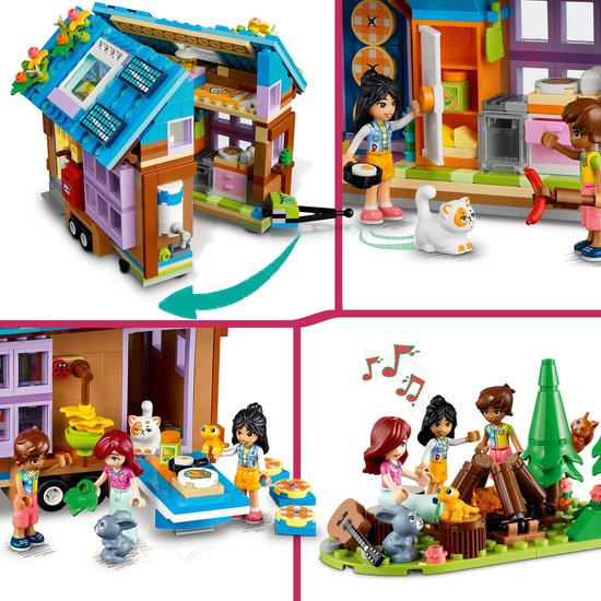 Een Lego Friends tiny house op wielen met een oranje auto, kampeerplek met kampvuur, drie speelfiguren en dieren.