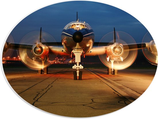 WallClassics - PVC Schuimplaat Ovaal - Vooraanzicht van Vliegtuig in de Avond - 40x30 cm Foto op Ovaal (Met Ophangsysteem)