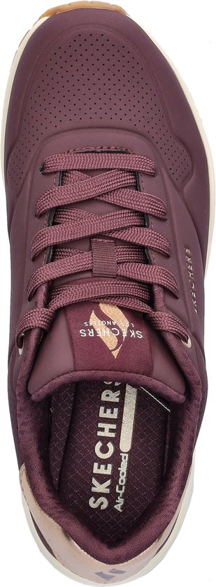 Bovenaanzicht van een paarse Skechers sneaker met veters, gouden accenten en 'Skechers Air-Cooled' op de binnenzool.