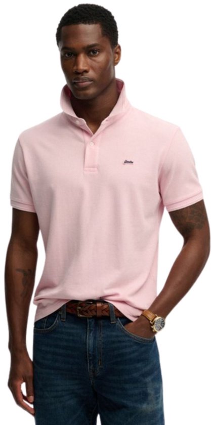 Mannequin portant un polo Superdry rose pâle à manches retroussées et un jean.