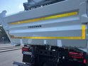 Witte achterkant van een vrachtwagen met "TRIGENIUS" en reflecterende gele strepen.