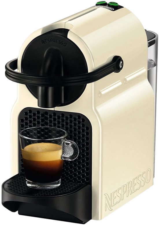 Machine à café à capsules Nespresso Inissia crème avec une tasse d'expresso.