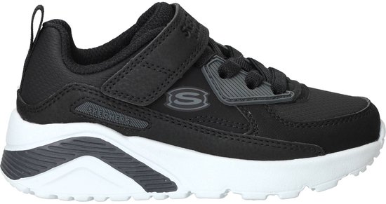 Zwarte sneaker met klittenbandsluiting en veters. Witte zool met grijze accenten. Skechers logo op de zijkant.