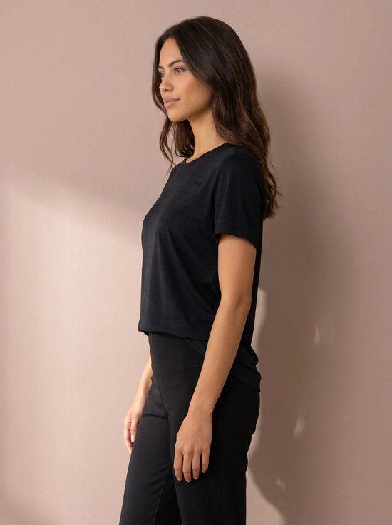 Model in een zwarte sportshirt met korte mouwen en een ronde hals. De stof heeft een subtiele textuur.