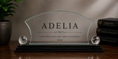 Glazen trofee met de tekst 'ADELIA' en 'VOOR PRESTATIES, MET TROTS UITGEREIKT 2024'.