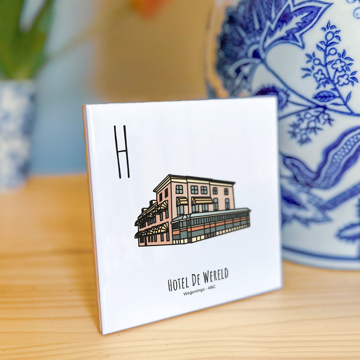 Hotel De Wereld - ABC tegeltje Wageningen - Keramiek met Handgetekende Illustratie - Wanddecoratie - Woondecoratie - Relatiegeschenk - Souvenir - 10,8 x 10,8 cm