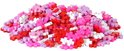 Een hoop rode, roze en paarse Plus-Plus bouwstenen.