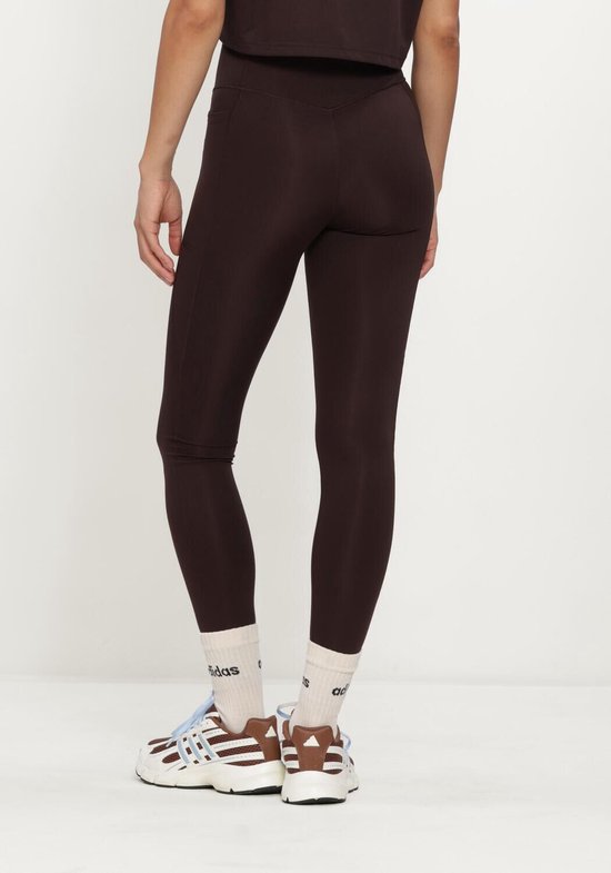 Achterkant van een bruine legging met een wit Adidas-logo op de linkerheup.