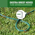 Groene tuinslang vastgezet met grondpinnen op gras. Gedetailleerde weergave van de brede kop van de pin.