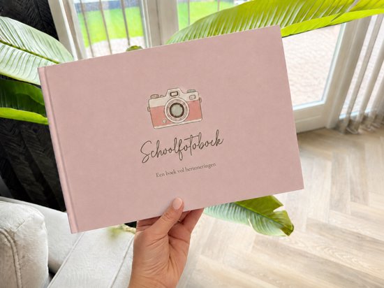 Een roze kaft van een schoolfotoboek met een getekende roze camera en de tekst 'Schoolfotoboek'.