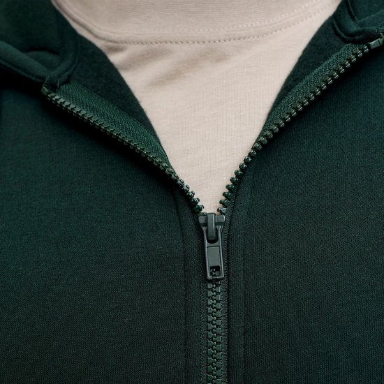 Sluiting van de donkergroene hoodie, met ritssluiting en beige T-shirt.