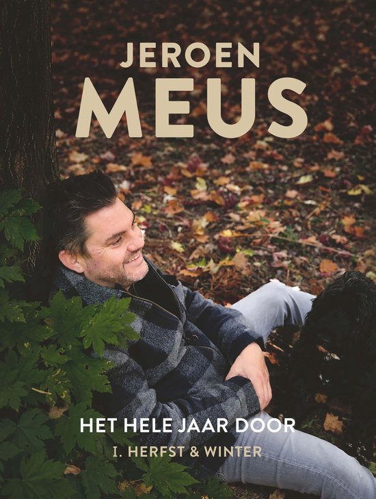 Jeroen Meus à l'automne, assis contre un arbre, avec un chien.