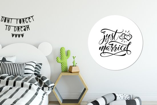 Un cercle mural avec le texte 'just married' en écriture élégante, avec deux cœurs au-dessus.