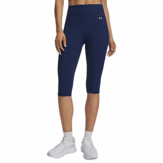 Blauwe Under Armour capri sportlegging met hoge taille, gedragen door een vrouw met witte sneakers en sokken.