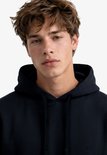 Close-up van model met donkerblauwe hoodie met capuchon.