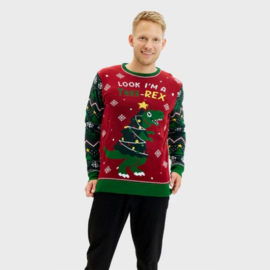 Een man draagt een rode kersttrui met een dinosaurus, kerstboom, lichtjes en de tekst "LOOK I'M A TREE-REX".