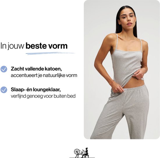 Model in een grijze pyjama met spaghettibandjes, zachtvallende katoen, accentueert natuurlijke vorm.