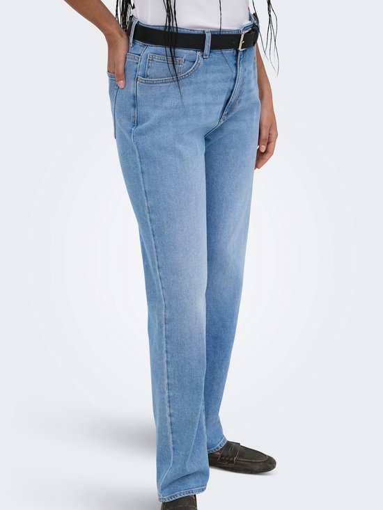 Model met een lichtblauwe mom fit jeans met rechte pijpen en zwarte riem.