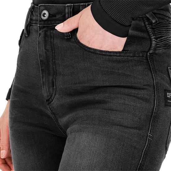 Detail van de grijze dames motorjeans met knopen, zak en een 'SHIMA' label op de achterzak.