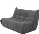 Grijze, zachte vloersofa met gewatteerde zitting en plooien, op witte achtergrond.