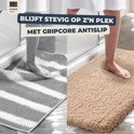 Grijze gestreepte badmat en beige badmat met antislip onderkant.