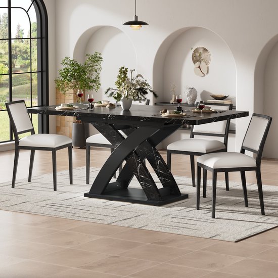 Zwarte eettafel met marmerlook en een X-vormig onderstel, gedekt met witte stoelen.