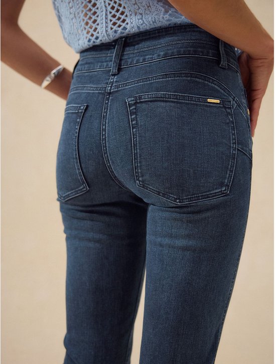 Achterkant van een donkerblauwe slim jeans met rechte pijpen en kenmerkende zakken.
