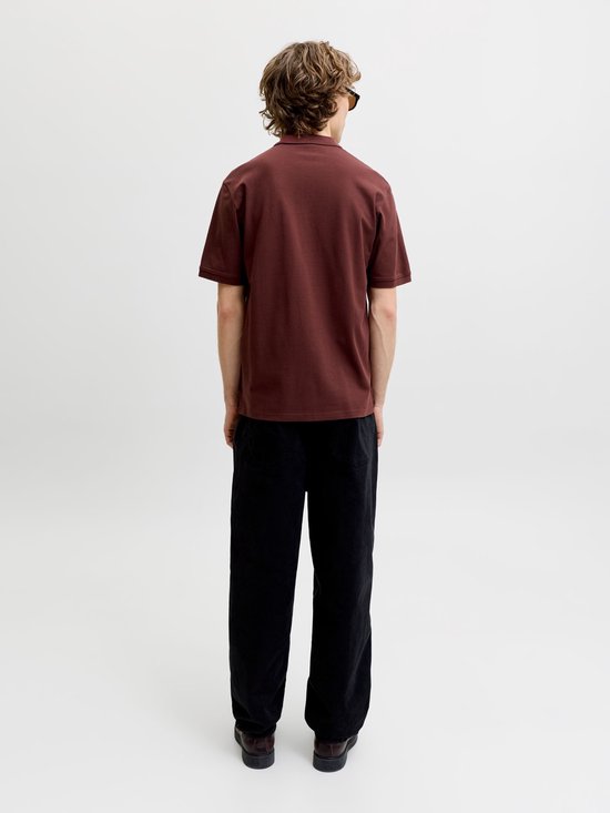 Achterkant van een man in een donkerbruine polo en zwarte broek