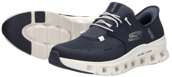 Paar marineblauwe Skechers sneakers, één met witte veters en witte zool, de ander van de zoolkant.