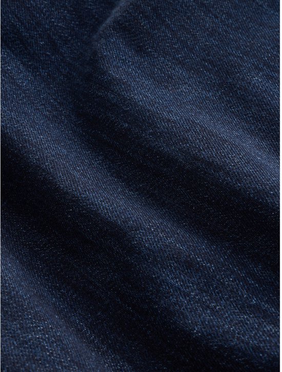 Close-up van donkerblauwe denimstof met een subtiele textuur.