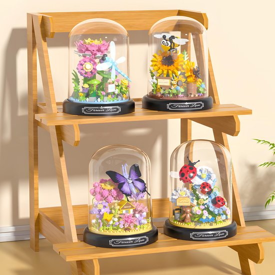 Vier glazen stolpen met micro mini blokjes: lieveheersbeestjes, bij, vlinder en libelle, op een houten rek.