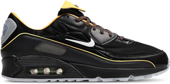 Zwarte Nike Air Max 90 sneaker met witte Swoosh, oranje accenten en doorschijnzool.
