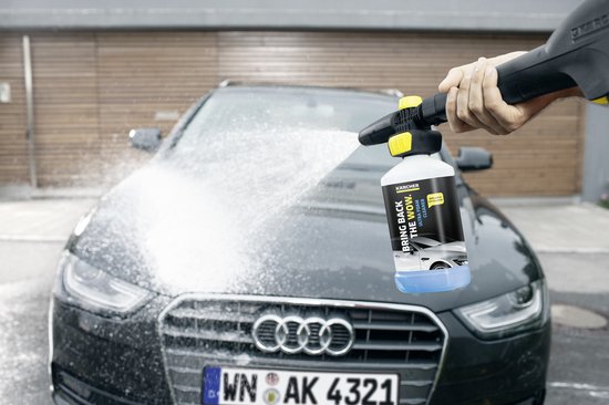 Karcher schuimsproeier met "BRING BACK THE WOW" op de fles, spuit schuim op een zwarte Audi.