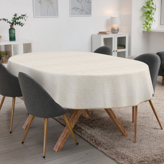 Ovaal tafelkleed met een beige gebladertepatroon op een ovale tafel, omringd door stoelen.