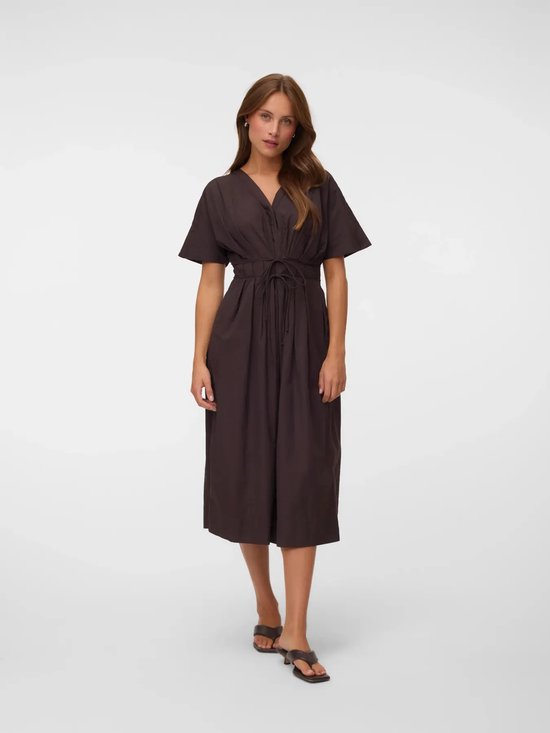 Mannequin dans une robe marron avec col en V, manches courtes, ceinture et sandales.